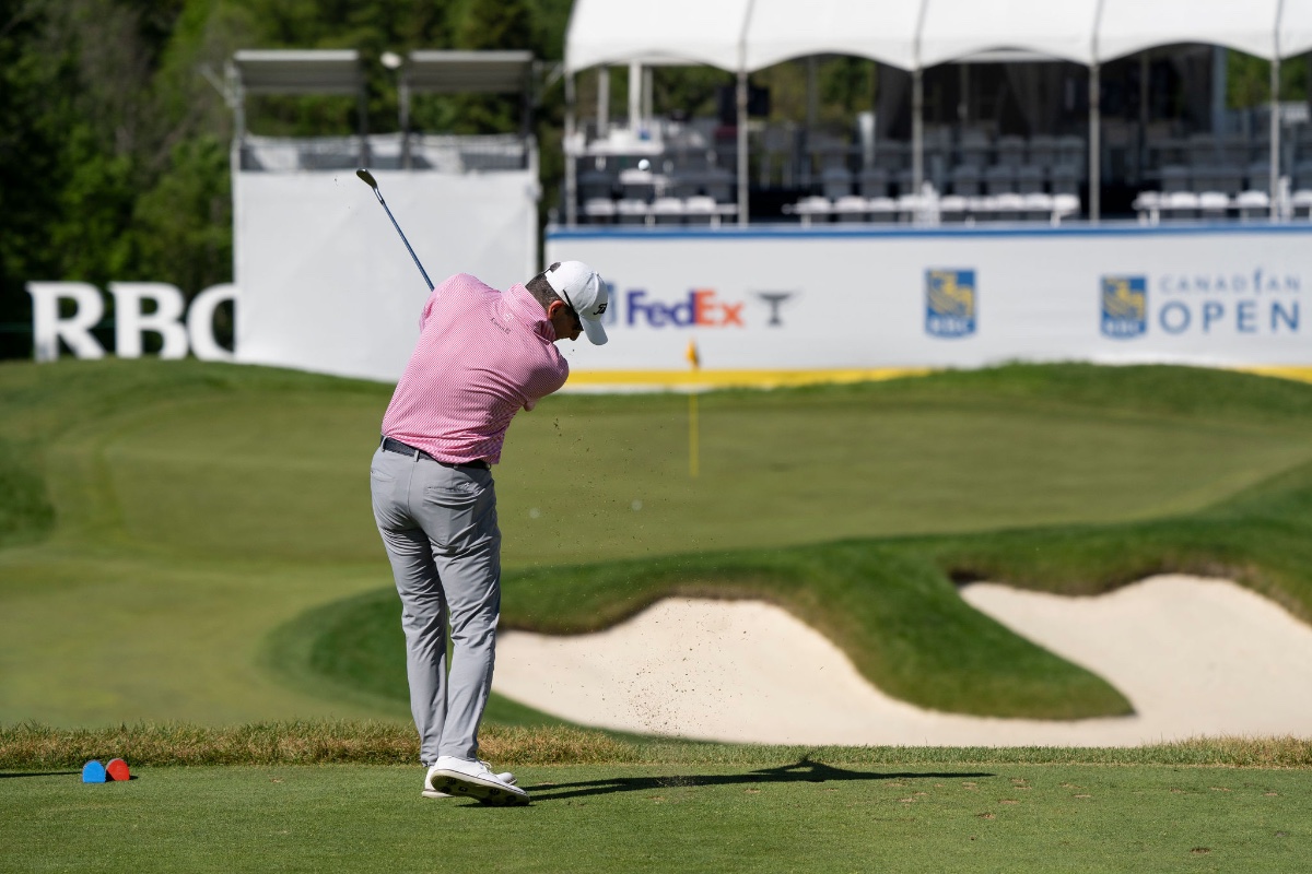 PGA Tour golfer striking a crisp approach shot with a divot flying at the RBC Canadian Open Rink Hole with FedEx and RBC Canadian Open signage behind, sports photography by Toronto photographer Quinton Meyer